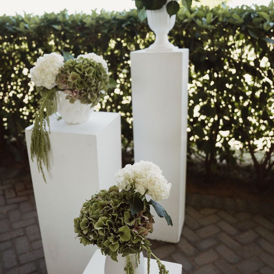 Ceremony floral arrangements on white plinths